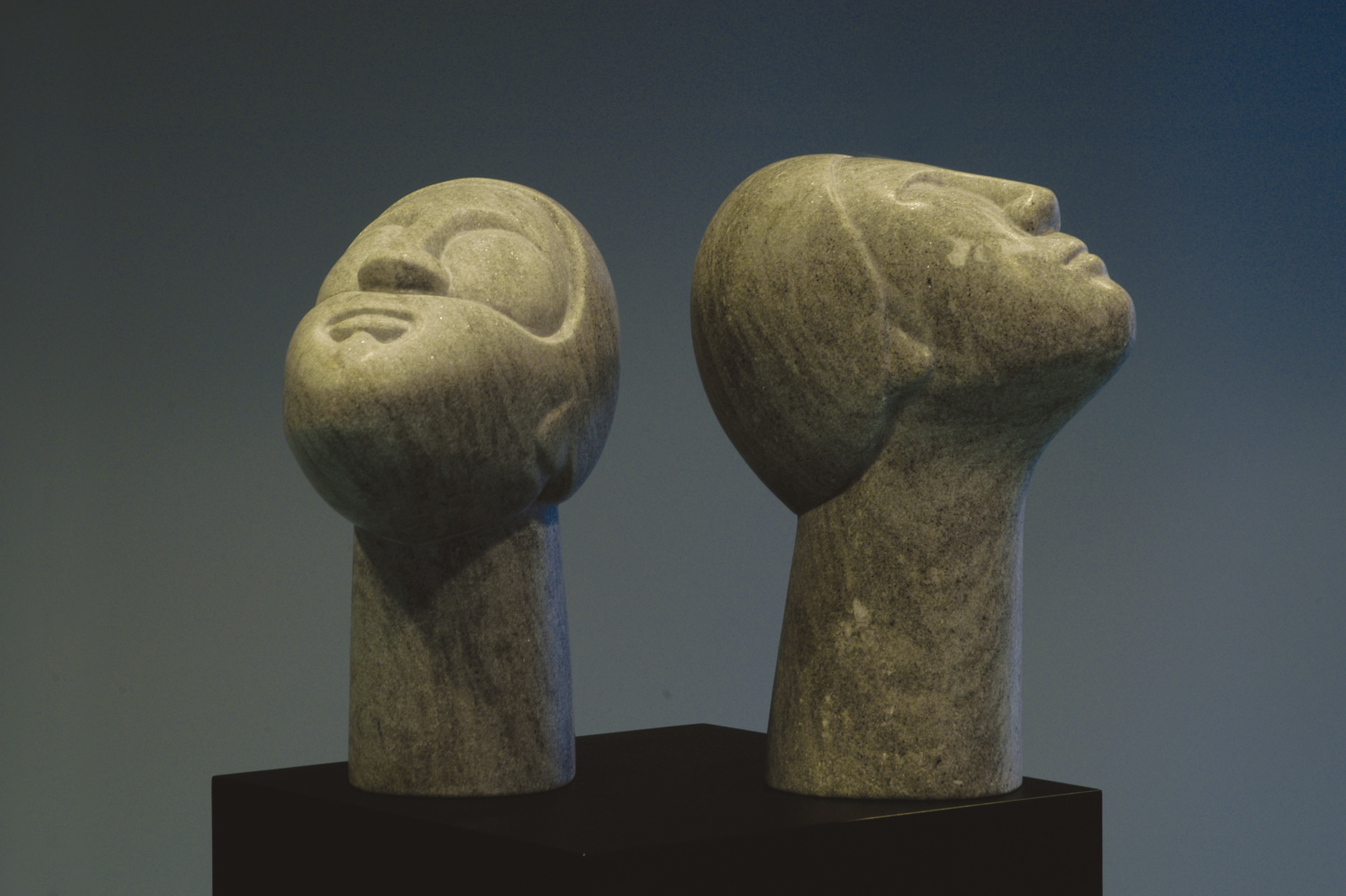 Scultura in marmo — due teste che guardano in su, di Clara