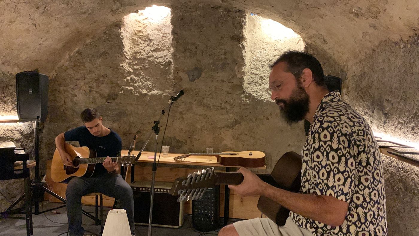Due musicisti con le chitarre nella cantina a volta di Casa Piumogna